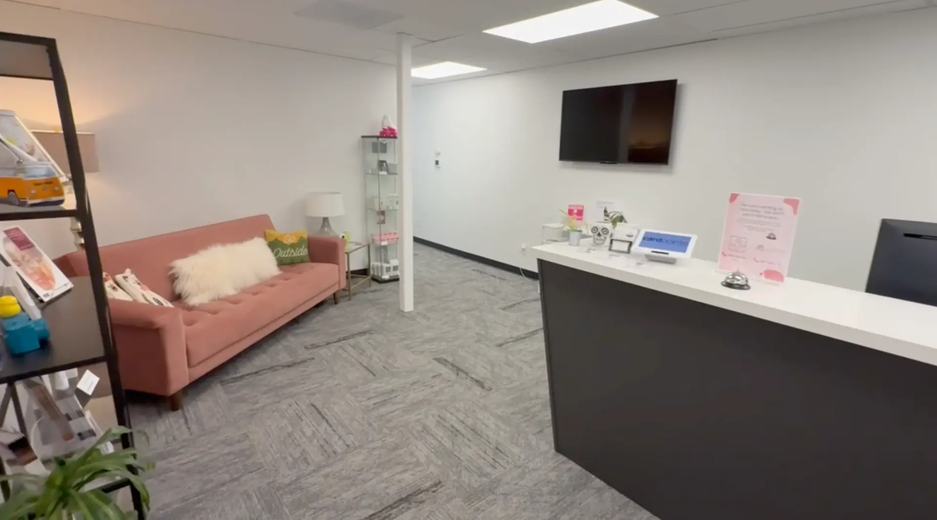 Storm Wellness Northwest waiting room with a pink couch, retail shelving, and front desk