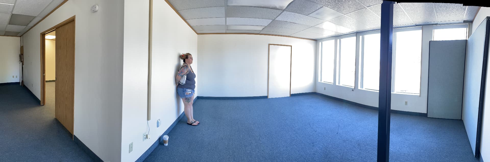 Panoramic view of the empty original office space with one of the founders standing against the wall